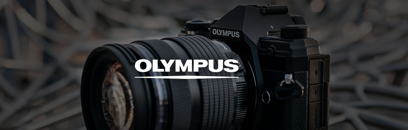 Fotoaparát Olympus so širokouhlým objektívom, zobrazený zblízka na rozmazanom abstraktnom pozadí Fotoaparát Olympus so širokouhlým objektívom, zobrazený zblízka na rozmazanom abstraktnom pozadí