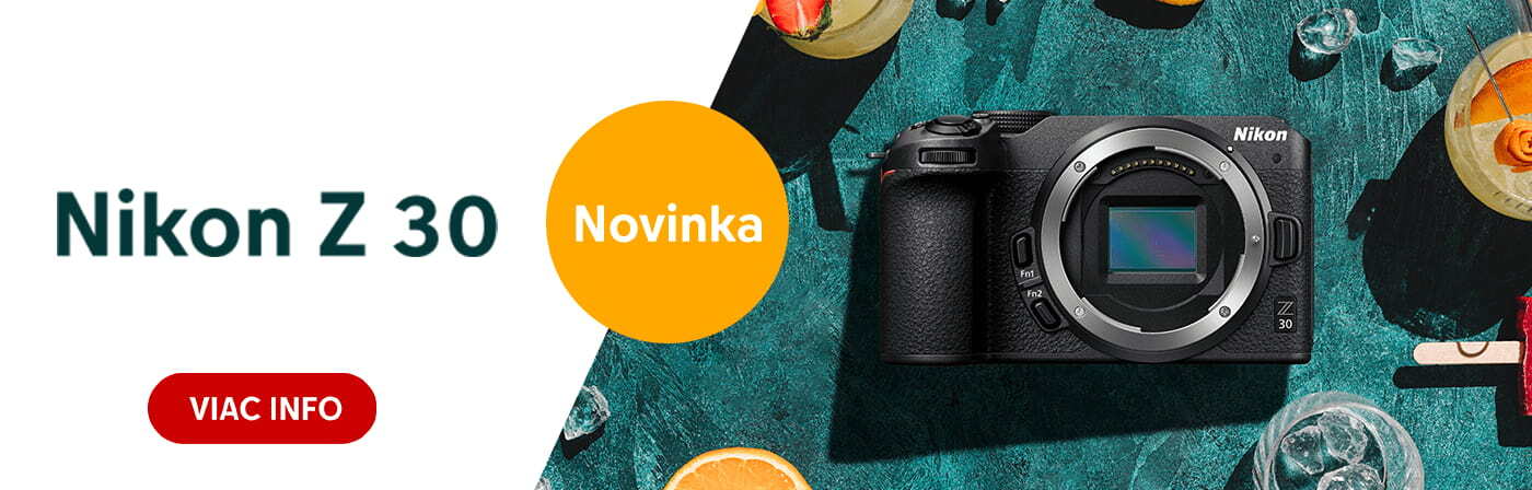 Fotoaparát Nikon Z 30 položený na zelenom stole obklopenom farebnými nápojmi a pomarančovými plátkami