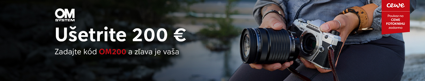 Osoba držiaca fotoaparát OM System s krajinou v pozadí