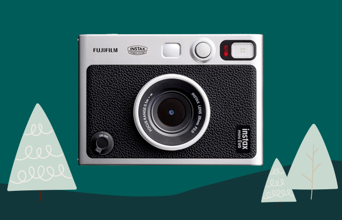 Štýlový fotoaparát Fujifilm Instax Mini Evo so striebornými detailmi na tmavozelenom pozadí s ilustrovanými stromčekmi
